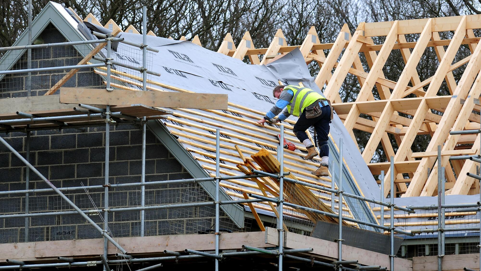Ouvrier sur la structure bois du toit